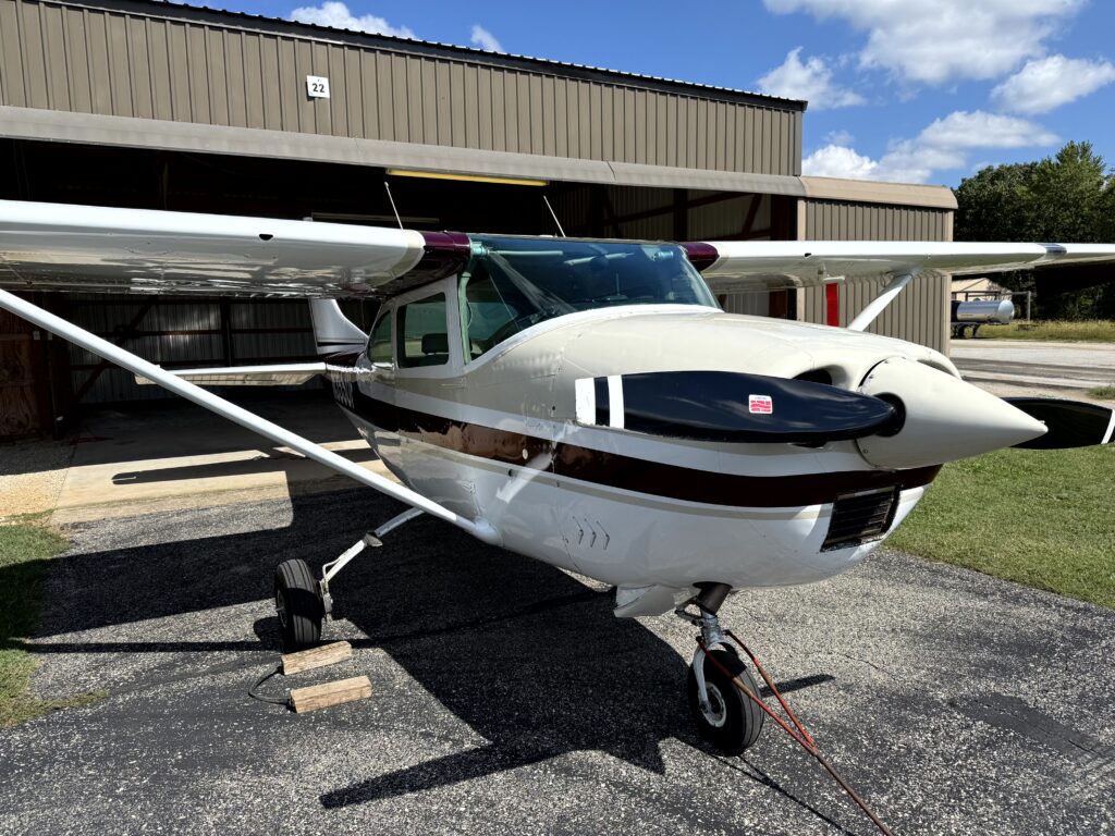 Single-engine aircraft parked outside a hangar
